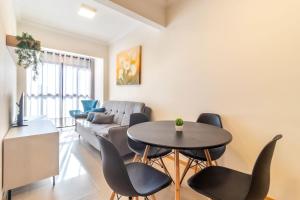 a living room with a table and chairs and a couch at Apto funcional no Centro de Blumenau UG6156 in Blumenau