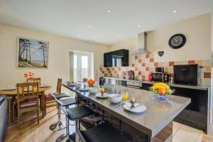 een keuken met een lang eiland in een kamer bij Farriers Cottage in Blofield