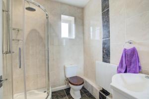 een badkamer met een douche, een toilet en een wastafel bij Farriers Cottage in Blofield +12 foto's