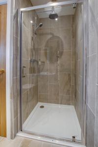 a shower with a glass door in a bathroom at The Old School House in Reepham +5 photos