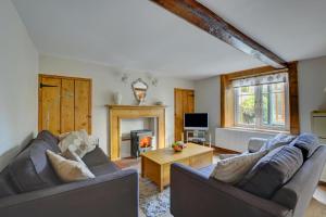 a living room with two couches and a fireplace at Folly Cottage in Bodham