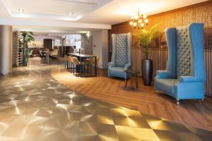 a lobby with two blue chairs and a table at Leonardo Vienna Westbahnhof in Vienna +25 photos