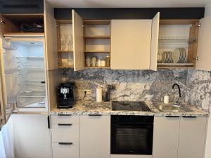 a kitchen with white cabinets and a sink at JK apartment in Rēzekne