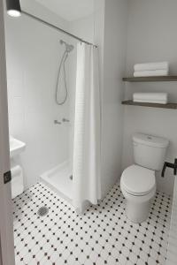 a white bathroom with a toilet and a shower at CityNest Hotel in New York