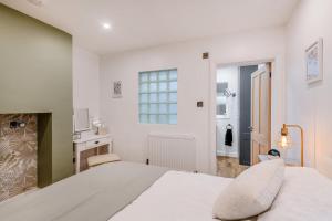 ein weißes Schlafzimmer mit einem Bett und einem Kamin in der Unterkunft Quayside Cottage in Rye