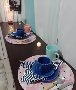 two plates and cups on a table in a kitchen at Stúdio inteiro climatizado próximo a praia - ambiente familiar in Itapema