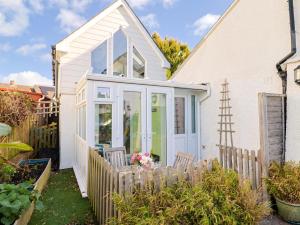 ein Haus mit einer weißen Tür und einem Zaun in der Unterkunft Cherry Pip in Charmouth