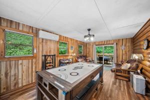 sala de estar con paredes de madera y mesa en The Smore the Bearier, en Zionville