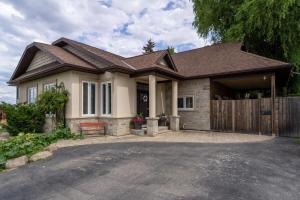 a house with a wooden fence and a driveway at 4 Bedroom Stoney Creek Nature Oasis Sauna, Games & Luxury Comfort in Hamilton