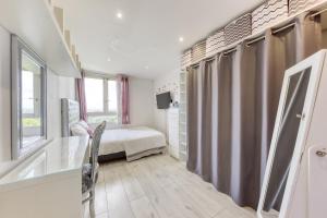 a bedroom with a bed and a window at Saint Lazare à portée de main in Argenteuil