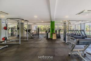 a gym with rows of treadmills and machines at Charmosos Flats no Setor Bueno TXP in Goiânia