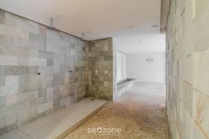 an empty room with a tile wall and a window at Charmosos Flats no Setor Bueno TXP in Goiânia