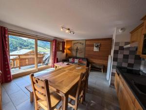 une cuisine et une salle à manger avec une table en bois dans l'établissement Chalet Du Bois De Suffin N°10 - Grand appartement de standing - 6/8 personnes MAE-8244, à Montgenèvre