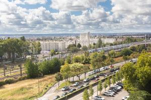 a city with a lot of cars parked on the street at Saint Lazare à portée de main in Argenteuil