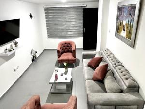 ein Wohnzimmer mit einer Couch und zwei Sesseln in der Unterkunft Apto moderno al norte cerca al Río Guatapurí in La Elvira