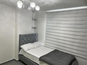 Schlafzimmer mit einem Bett mit grauem Kopfteil in der Unterkunft Apto moderno al norte cerca al Río Guatapurí in La Elvira