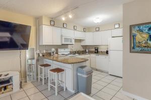 a kitchen with white cabinets and white appliances at Emerald Skye 36 in Orange Beach