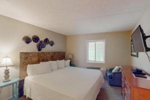 a bedroom with a bed and a desk and a television at Emerald Skye 36 in Orange Beach
