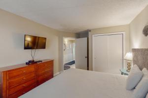 a bedroom with a white bed and a dresser and a closet at Emerald Skye 36 in Orange Beach +24 photos