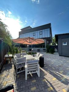 a patio with chairs and an umbrella in front of a building at City Villa in Koktobe