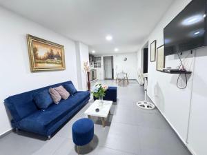 La ElviraにあるApartamento Norte Valledupar cerca Río Guatapuríの青いソファとテーブルのあるリビングルーム
