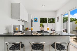 Tanki LenderVilla Bella Private Pool Retreat In Aruba的厨房配有带四把椅子的大柜台