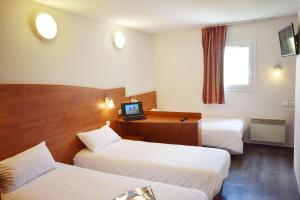 ein Hotelzimmer mit 2 Betten und einem Schreibtisch in der Unterkunft Brit Hotel Reims La Pompelle in Reims