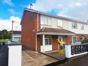 a red brick house with a white door at Three Bedroom House By Travel Lets Holiday Homes Strabane With Garden in Strabane