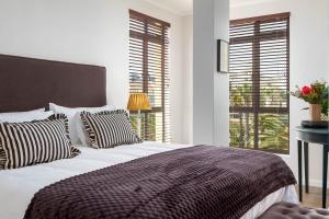 プリングル・ベイにあるLuxurious Palm View Apartment Cape Townの黒と白の枕が付いた大きなベッドのある寝室 +22枚の写真