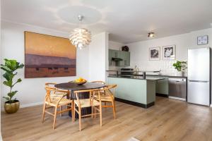 プリングル・ベイにあるLuxurious Palm View Apartment Cape Townのテーブルと椅子のあるキッチンとダイニングルーム