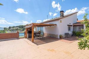 una casa y un patio con pérgola de madera en Private Pool Sea Views Bellvei Villa Barcelona, en Calafell