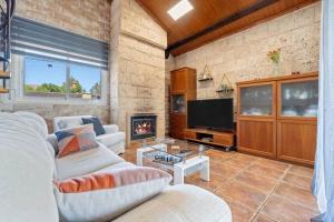 Una sala de estar con un sofá y una chimenea. en Private Pool Sea Views Bellvei Villa Barcelona, en Calafell