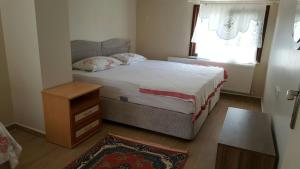 a bedroom with a bed and a table and a window at Suna Apart Hotel in Gokceada Town