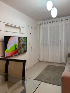 un salon avec une table en verre et une télévision dans l'établissement Prático e Aconchegante, à Porto Alegre