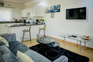 a living room with a couch and a kitchen at Villa Stone Apartments in Lusaka