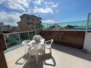 Cód 18 · Cobertura Duplex com piscina e vista mar في جوفيرنادور سيلسو راموس: طاولة وكراسي بيضاء على شرفة