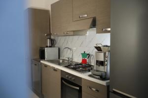 Una pequeña cocina con estufa y microondas. en CASA VACANZE VIA CASALE, en Nardò 17 fotos más