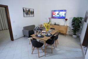 Una sala de estar con una mesa y sillas y un televisor. en CASA VACANZE VIA CASALE, en Nardò