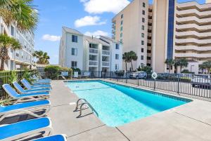 Una piscina con tumbonas al lado de unos edificios. en SHV B1: The Sweetbay, en Myrtle Beach