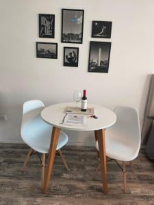 una mesa con dos sillas y una copa de vino. en @juanbjustoapartamento, en Buenos Aires
