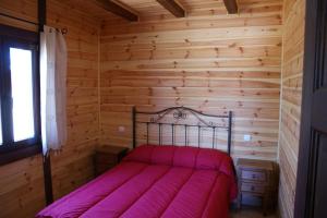 a bedroom with a bed in a log cabin at Lincetur Cabañeros - Centro de Turismo Rural in Navas de Estena