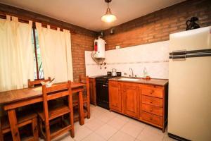 a kitchen with a refrigerator and a table and a sink at Nélida Dpto 1 in Villa Carlos Paz