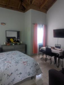 ポートモアにある2 Bedroom upstairs large flat in Portmore Pinesのベッドとテーブルと椅子のある寝室