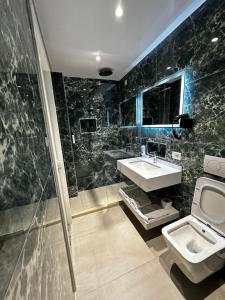 a bathroom with a sink and a shower and a toilet at Dedej Rooms in Durrës
