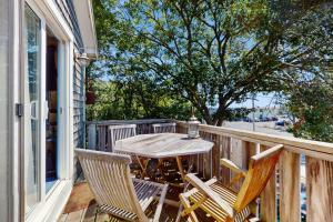 eine Veranda mit einem Tisch und Stühlen auf dem Balkon in der Unterkunft The Blue Cottage in Provincetown + 7 Fotos
