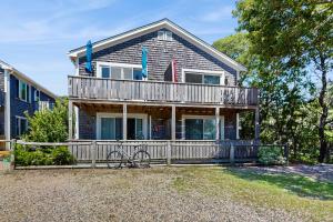 ein Haus mit einem Balkon, auf dem ein Fahrrad steht in der Unterkunft The Blue Cottage in Provincetown