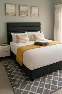 a bedroom with a large bed with white sheets and pillows at SinoVilla397 in Pretoria
