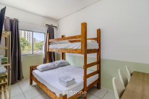 a bedroom with two bunk beds and a table at Lindos Lofts no Centro de Floripa - FLT in Florianópolis