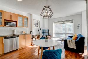 a kitchen and living room with a table and a couch at Le Mille Neuf Apartments Modern Comfort in Downtown Montreal in Montréal