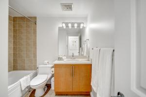 a bathroom with a toilet and a sink and a bath tub at Le Mille Neuf Apartments Modern Comfort in Downtown Montreal in Montréal +56 photos